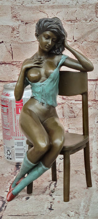 AN EROTIC BRONZE SCULPTURE OF A SEMI-NAKED WOMAN IN A CHAIR BY MILO STATUE