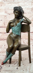 AN EROTIC BRONZE SCULPTURE OF A SEMI-NAKED WOMAN IN A CHAIR BY MILO STATUE