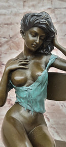 AN EROTIC BRONZE SCULPTURE OF A SEMI-NAKED WOMAN IN A CHAIR BY MILO STATUE