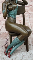 AN EROTIC BRONZE SCULPTURE OF A SEMI-NAKED WOMAN IN A CHAIR BY MILO STATUE