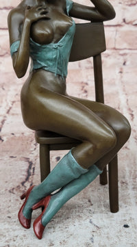 AN EROTIC BRONZE SCULPTURE OF A SEMI-NAKED WOMAN IN A CHAIR BY MILO STATUE