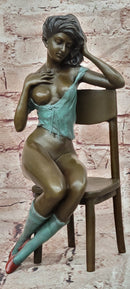 AN EROTIC BRONZE SCULPTURE OF A SEMI-NAKED WOMAN IN A CHAIR BY MILO STATUE