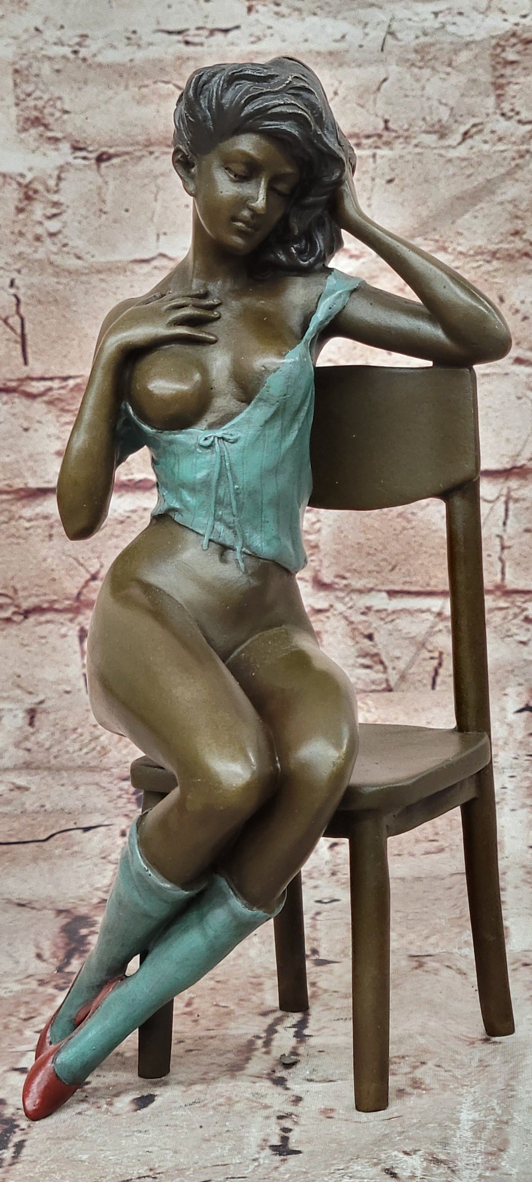 AN EROTIC BRONZE SCULPTURE OF A SEMI-NAKED WOMAN IN A CHAIR BY MILO STATUE