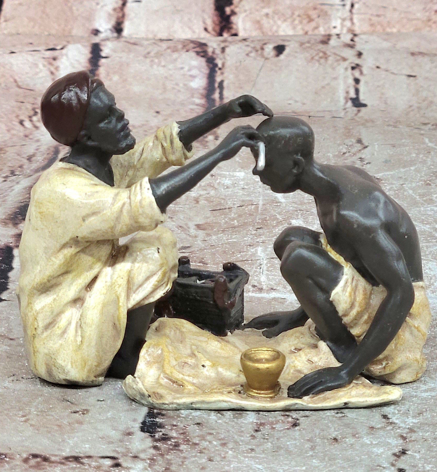 A Franz Bergman cold painted bronze figural group of an Arab barber at work