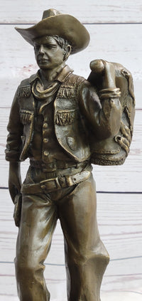 Cowboy in Chaps Carrying Horse Saddle Bronze 12" x 4"