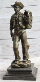 Cowboy in Chaps Carrying Horse Saddle Bronze 12" x 4"