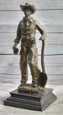 Cowboy in Chaps Holding Shovel Bronze 12" x 5"