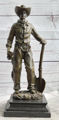 Cowboy in Chaps Holding Shovel Bronze 12" x 5"