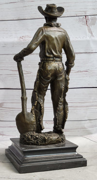 Cowboy in Chaps Holding Shovel Bronze 12" x 5"