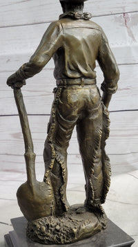 Cowboy in Chaps Holding Shovel Bronze 12" x 5"