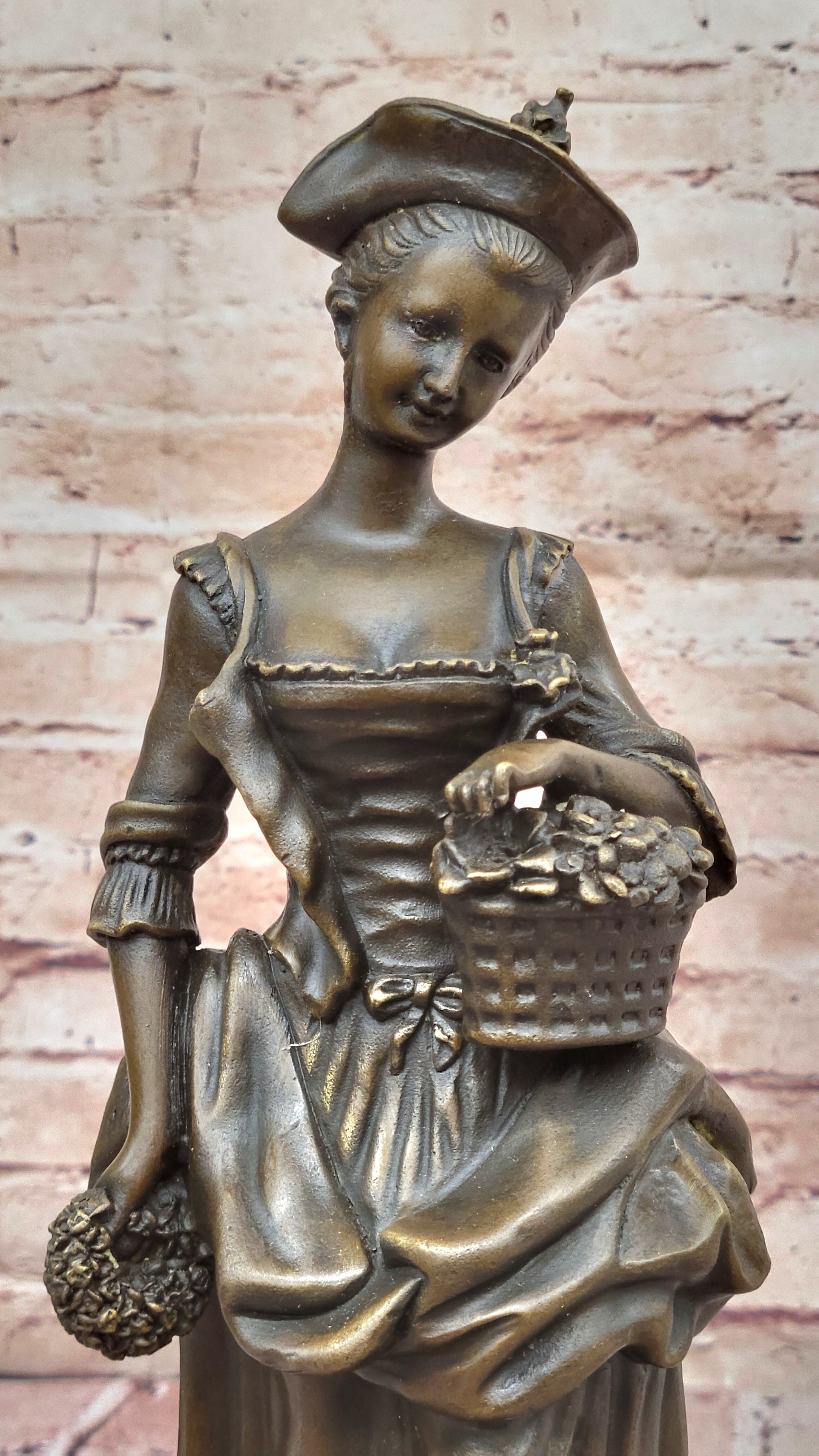 Bronze Sculpture of Woman in Traditional Dress Holding Basket