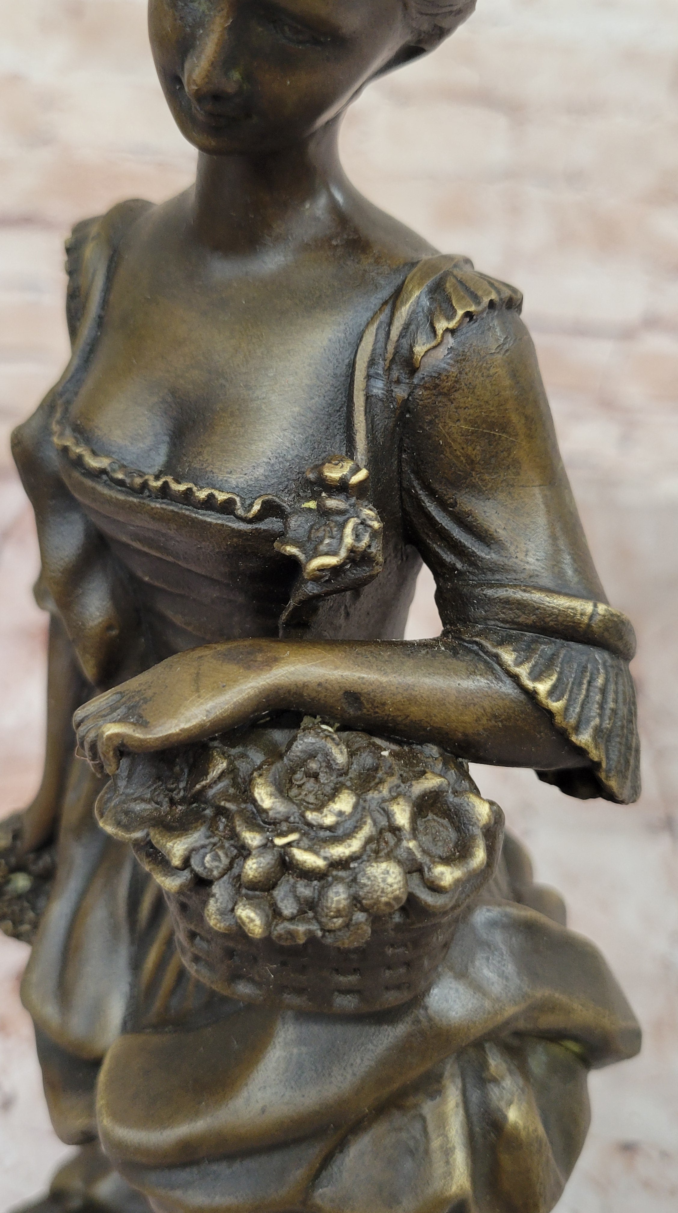 Bronze Sculpture of Woman in Traditional Dress Holding Basket